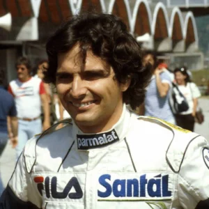 Nelson Piquet sorridente em trajes de piloto, expressão de leveza e persona integrada